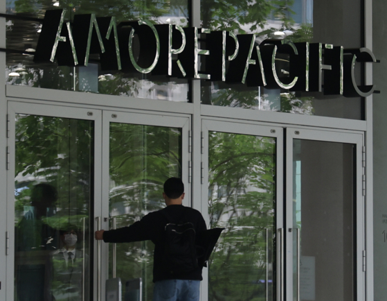 An employee enters Amorepacific Group’s headquarters in Yongsan District, central Seoul. [YONHAP]