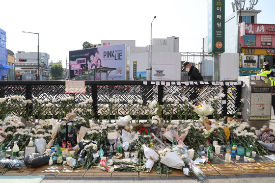 Flowers, bouquets, bottles of soju and letters are piled up in front of Exit No. 1 of Itaewon Station on Monday. [WOO SANG-JO]