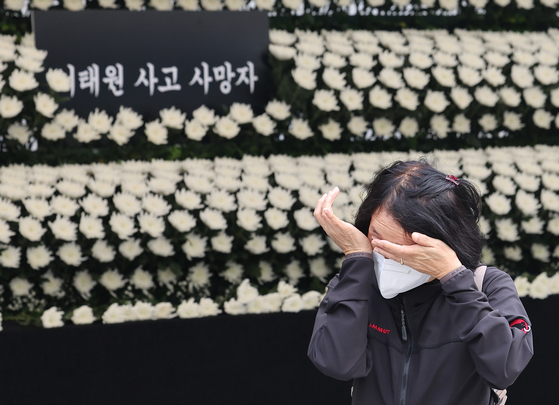 A woman sheds tears after paying tribute to the victims of a crowd crush in the Itaewon area at a joint memorial altar at Seoul Plaza, central Seoul, on Tuesday. [YONHAP]