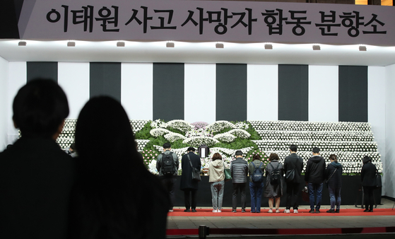 Mourners pay respects at a joint memorial set up near Seoul Plaza in Jung District, central Seoul on Monday night to those who died in the Itaewon crowd crush. [NEWS1]