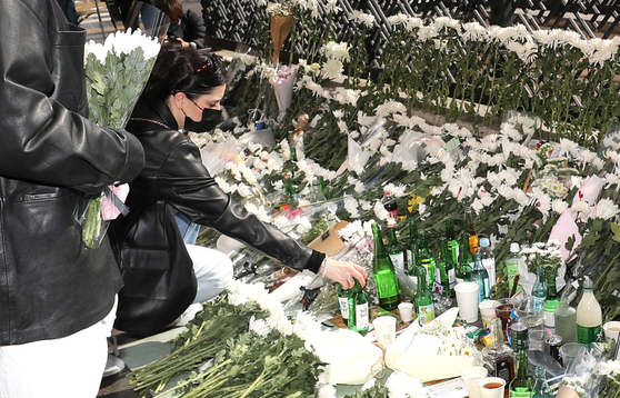 Visitors mourn the victims of Satuday's crowd crush in central Seoul's Itaewon at a memorial space in front of Itaewon Station exit 1 on Monday. [NEWS1]