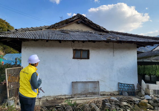 A Goesan County official makes an on-site inspection following a report that roof tiles fell off a house in the county in North Chungcheong, on Oct. 29. [YONHAP]