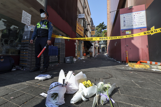Flowers are placed in the alleyway next to Hamilton Hotel on Sunday, a day after the Halloween crowd crush that took the lives of over 150 people. [JOONGANG ILBO] 