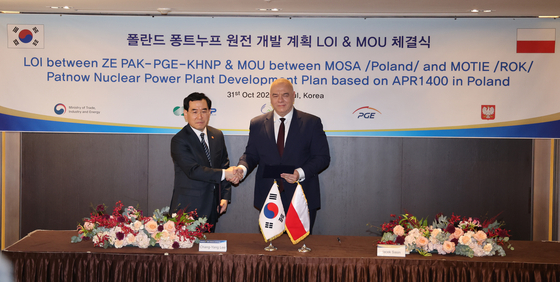 Minister of Trade, Industry and Energy Lee Chang-yang and Jacek Sasin, Poland's minister of State Assets, sign a memorandum of understanding for cooperation between the two countries on nuclear energy development in Seoul on Monday. [YONHAP]