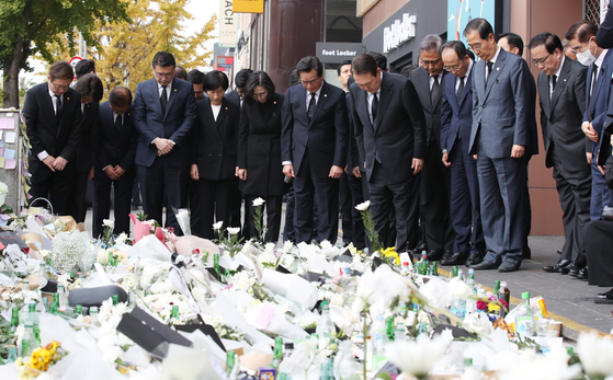 President Yoon Suk-yeol and his Cabinet members pay their respects at a makeshift memorial space for the victims of Halloween tragedy outside Exit No. 1 of Itaewon Station in Yongsan District, central Seoul, on Tuesday. [YONHAP]