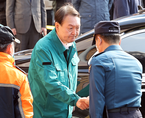 President Yoon Suk-yeol greets a police official after inspecting the site of the deadly crowd crush in Itaewon in central Seoul, on Oct. 30. [YONHAP]