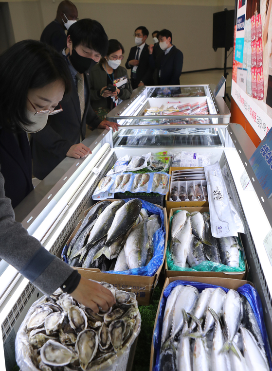 Visitors examine fish products at the 2022 Busan International Fisheries Expo, held at the Busan Exhibition and Convention Center in Busan on Wednesday. The expo features 330 companies from 22 countries and will be held until Saturday. In addition to exhibition events, various programs on trade, academic events and discount events to promote seafood consumption are being held during the expo. [YONHAP]