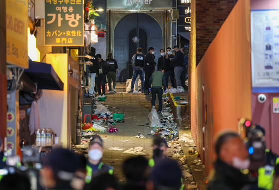 Police and the fire department investigate the alleyway next to the Hamilton Hotel in Itaewon on Sunday morning, the site that took the lives of over 150 people on Saturday. [JOONGANG ILBO] 