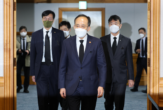 Finance Minister Choo Kyung-ho, center, enters a room to participate in a meeting held in central Seoul to discuss economic matters on Thursday. [NEWS1]