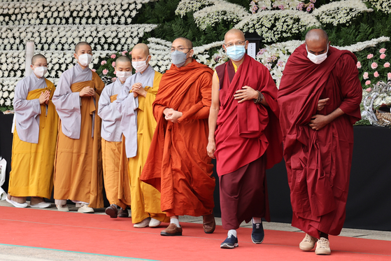 Buddhist monks from Southeast Asian countries pay their respects to the victims of the Itaewon tragedy at a mourning altar set up on the Seoul Plaza on Thursday. [YONHAP]