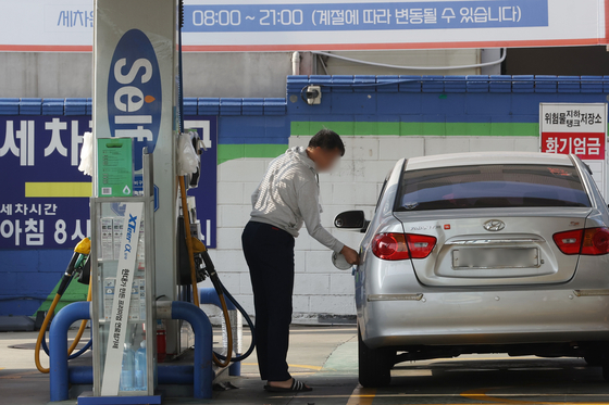 A customer pumps gas at a station in Seoul. [YONHAP]