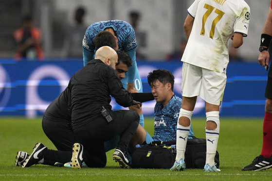 Tottenham Hotspur's Son Heung-min receives treatment after taking a knock during a UEFA Champions League Group D match against Marseille at the Stade Velodrome in Marseille, France on Nov. 1. [AP/YONHAP]