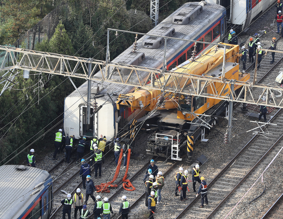 Korea Railroad Corporation (Korail) workers engage in recovery work on Monday morning after a trail derailed near Yeongdeungpo Station in western Seoul on Sunday night. [NEWS1]