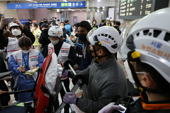 Rescue operators check lists of injuries at Yeongdeungpo Station in central Seoul after a train with 275 passengers aboard derailed while entering the station on Sunday. [YONHAP]