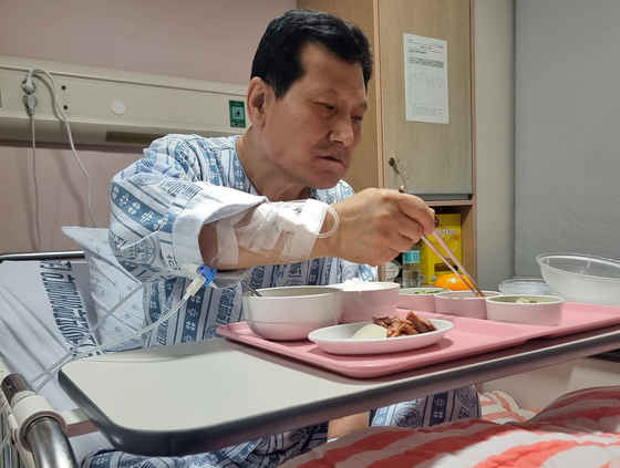Park Jung-ha, one of the last two rescued miners, eats dinner in his hospital bed at Andong Medical Group Hospital in Andong, North Gyeongsang, with his eye mask off on Monday afternoon. [NEWS1] 
