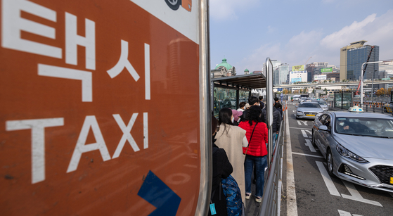 People wait to get a taxi at Seoul Station, central Seoul, on Tuesday. [YONHAP]