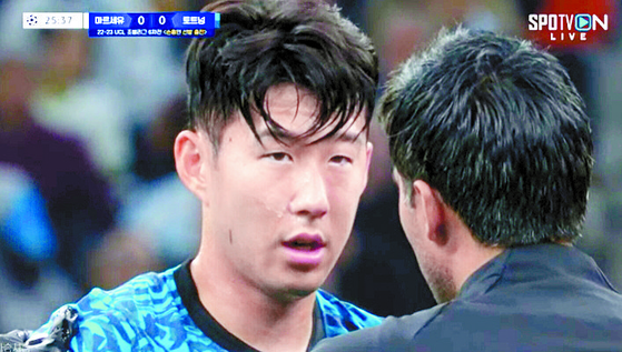 Son Heung-min is seen in a screen capture of a SPOTV broadcast talking to medical staff after injuring his face during a game against Marseille on Nov. 1.  [SCREEN CAPTURE]