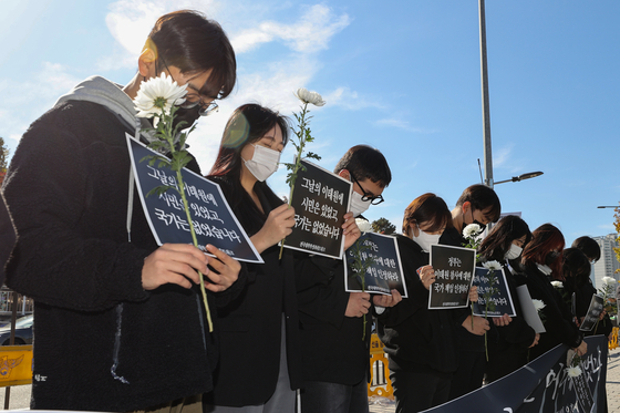 Members of the National University Student Council Networks pay silent tribute at a press conference held to commemorate the death of the victims of the Itaewon tragedy near the Yonsan presidential office on Nov. 4. [YONHAP] 
