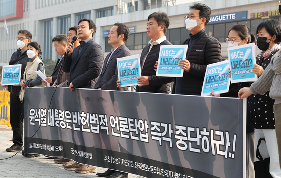 A group of journalist associations hold a press conference near the presidential office in Yongsan District, central Seoul, Thursday, calling for the presidential office to withdraw its decision to bar broadcaster MBC from traveling on the presidential jet. [YONHAP]