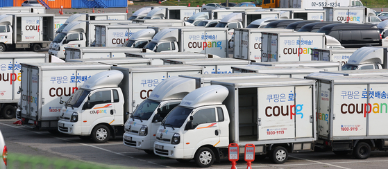 Coupang trucks are parked in a parking lot in Seoul. [YONHAP]
