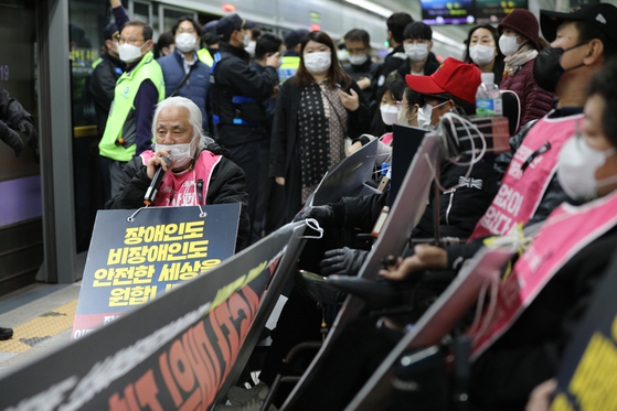 A group of handicapped people stage a rally on a subway platform in Gwanghwamun Station in central Seoul on Thursday demanding greater government spending on the handicapped. The group has been staging demonstrations in the subway during morning rush hours since December 2021. [NEWS1]