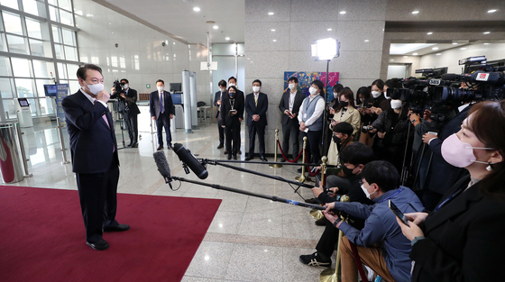 President Yoon Suk-yeol takes questions from reporters Thursday morning at the presidential office in Yongsan, central, on his way to work. [YONHAP] 