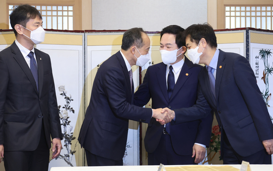From second left to right, Finance Minister Choo Kyung-ho, Land Minister Won Hee-ryong and Financial Services Commission Chairman Kim Joo-hyun greets each other before the government's meeting on the real estate market at the government complex in Seoul on Thursday. [YONHAP]