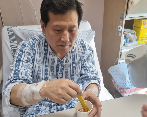 Park Jung-ha, one of the two miners trapped in a zinc mine for 221 hours after it collapsed, drinks instant coffee, which helped him survive while waiting in the mine for nine days. [YONHAP]