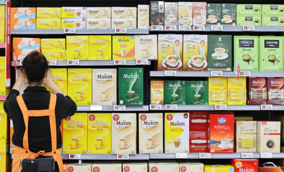 An employee displays Maxim instant coffee mixes in a discount mart in Seoul. [YONHAP]
