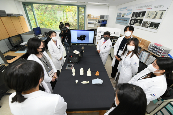 Visitors look at how 3-D scanning and 3-D printing works at the center for cultural heritages. [YIM SEUNG-HYE] 