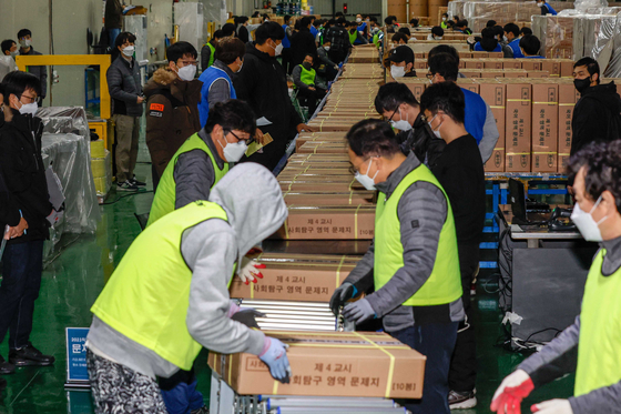 Workers sort boxes of test sheets for this year’s College Scholastic Ability Test (CSAT) at a printing plant in Sejong on Monday, three days ahead of the yearly exam. [YONHAP]
