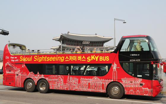 Seoul City Tour's open-roof city tour bus runs past Gwanghwamun in central Seoul. [YONHAP]