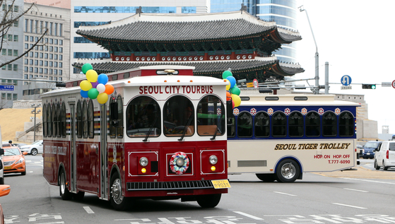 Seoul City Tour's Trolley Bus runs past Sungnyemun in central Seoul. [KIM SU-JEONG]