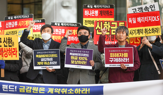 A group of people that invested in the German Heritage derivative-linked (DLS) securities products demand compensation in front of the Financial Supervisory Service office in western Seoul on Monday. [YONHAP]  
