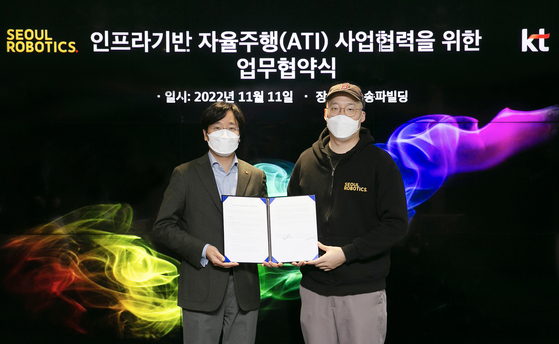 Choi Gang-lim, left, head of KT's AI Mobility division, and Seoul Robotics CEO Lee Han-bin pose for a photo during a signing ceremony held on Friday in Songpa District, southern Seoul. [KT]