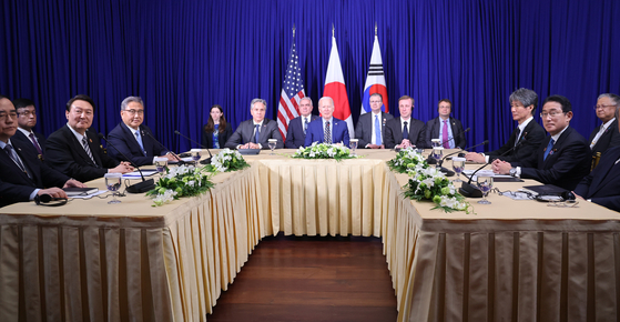 South Korean President Yoon Suk-yeol, center on the left table, U.S. President Joe Biden, center, and Japanese Prime Minister Fumio Kishida, far right on the right table, during a trilateral summit in Phnom Penh on Sunday [YONHAP]