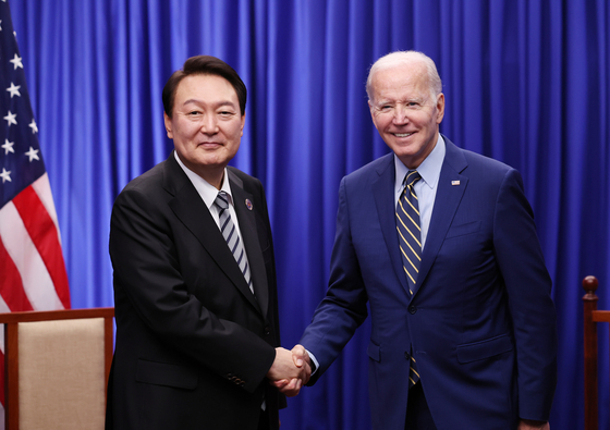 Korean President Yoon Suk-yeol, left, and U.S. President Joe Biden shake hands ahead of their bilateral summit at a hotel in Phnom Penh Sunday. [YONHAP] 