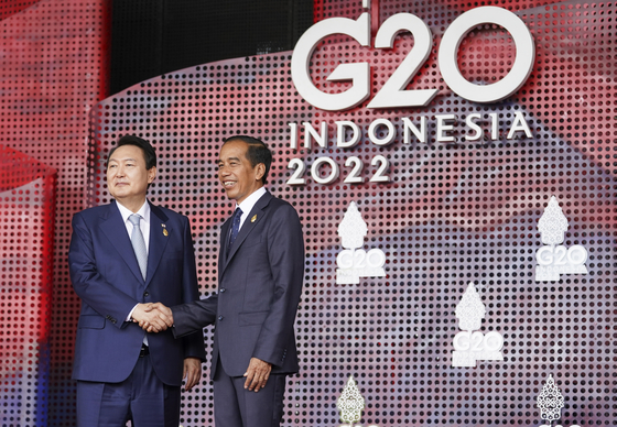 Korean President Yoon Suk-yeol, left, greets Indonesian President Joko Widodo at the G20 leaders' summit in Bali, Indonesia Tuesday. [AP/YONHAP]