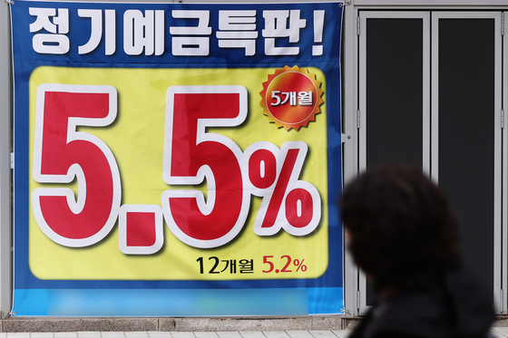 A banner in front of a bank in Seoul promotes the interest rate for deposit on Tuesday. The interest rate for time deposits at commercial banks surpassed 5 percent along with the rise of the base interest rate. [YONHAP]