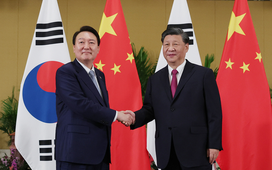President Yoon Suk-yeol, left, shakes hands with Chinese President Xi Jinping ahead of their first bilateral summit on the sidelines of the G20 summit in Bali, Indonesia Tuesday. [JOINT PRESS CORPS] 