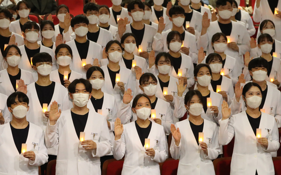 Nursing students at Ajou University in Suwon, Gyeonggi, take the Nightingale pledge, a modified version of the Hippocratic Oath, on Tuesday. [NEWS1]