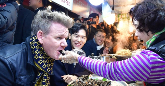Gordon Ramsay eats gimbap, or seaweed rice roll, at Gwangjang Market in Jongno District, central Seoul, during his 2017 trip to Korea. [ORIENTAL BREWERY]