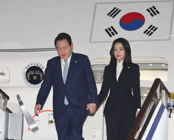 President Yoon Suk-yeol, left, and first lady Kim Keon-hee disembark from the presidential jet at Seoul Air Base in Seongnam, Gyeonggi, early Wednesday after concluding a six-day trip to Cambodia and Indonesia. [YONHAP]