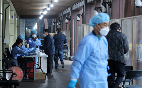 Health workers guide people visiting a Covid-19 testing center in Songpa District, southern Seoul, on Wednesday. [NEWS1]