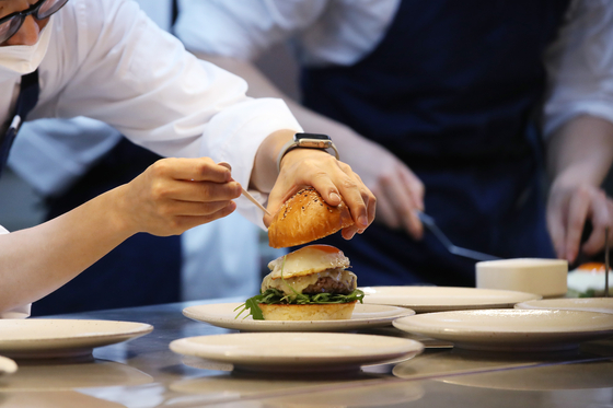 A premium burger is being crafted at Gordon Ramsay Burger in Songpa District, southern Seoul. [GORDON RAMSAY KOREA]