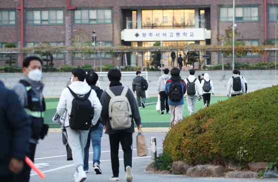 On Thursday morning, the day of the College Scholastic Ability Test, students walk into a high school campus to take the exam in Gwangju. [YONHAP]