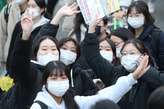 Students wave their hands excitedly at the main entrance to Hyehwa Girls’ High School in Daegu on Thursday afternoon after finishing the College Scholastic Ability Test (CSAT). [NEWS1]