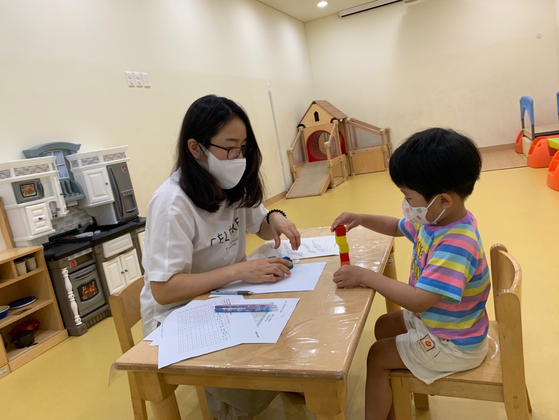 A researcher conducts a development screening test on a young boy. [CENTER FOR CHILD DEVELOPMENT AND DISABILITY AT EWHA WOMANS UNIVERSITY]