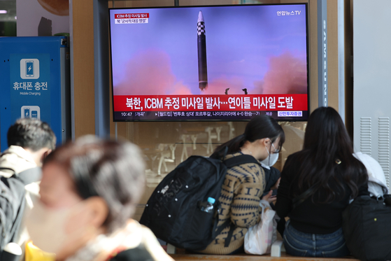 Passengers at Seoul Station sit in front of a morning news broadcast covering the latest missile launch by North Korea. [YONHAP]