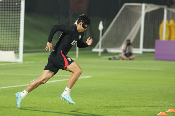 Son Heung-min sprints during Korean national team training in Doha, Qatar on Friday. Son, who is recovering from surgery on a facial injury, said on Wednesday that he has no problem running but has not attempted heading the ball.  [YONHAP]